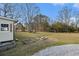 Spacious backyard featuring a gravel patio, mature trees, and garden beds, perfect for outdoor activities at 4951 Center Hill Church Rd, Loganville, GA 30052