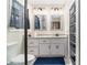 Bright bathroom featuring a granite countertop, dual mirrors and storage shelving at 4951 Center Hill Church Rd, Loganville, GA 30052