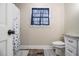 Bathroom featuring a tiled floor, standard toilet, and framed window with decorative blue curtains at 4951 Center Hill Church Rd, Loganville, GA 30052