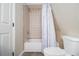 Bright bathroom with a tiled shower-tub combination and a classic white toilet at 4951 Center Hill Church Rd, Loganville, GA 30052