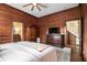 Bedroom features wood paneled walls, TV, dresser, closet, and stairway access at 4951 Center Hill Church Rd, Loganville, GA 30052