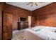 Bedroom features wood paneled walls, TV, dresser, closet and a window to a stairway at 4951 Center Hill Church Rd, Loganville, GA 30052