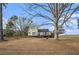 Quaint two-story home featuring shuttered windows, a black door, and rustic tree stump detail at 4951 Center Hill Church Rd, Loganville, GA 30052