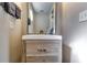 Stylish half bathroom featuring a wood vanity, modern faucet, and a rectangular mirror at 845 Connell Ln, Lawrenceville, GA 30044