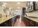 Modern kitchen with stainless steel appliances, granite countertops, and dark wood cabinets at 164 Charolais Dr, Mcdonough, GA 30252