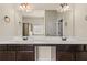 A bathroom featuring double sinks, dark cabinets, tiled floors, and a mirror reflecting the soaking tub and shower at 3257 Alhambra Cir, Hampton, GA 30228