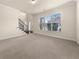 Light-filled living room with neutral carpet, staircase, and large window offering ample natural light at 3257 Alhambra Cir, Hampton, GA 30228