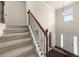 Inviting carpeted staircase featuring decorative metal and wood banisters, leading to the upper level of the home at 3257 Alhambra Cir, Hampton, GA 30228