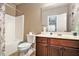 Bathroom with a combination shower-tub, wooden vanity, toilet, and stylish wall art at 5019 Lower Elm St, Atlanta, GA 30349