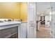 Laundry room with white front load washer and dryer, with an open doorway into a sitting room at 5019 Lower Elm St, Atlanta, GA 30349