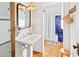 Charming bathroom with blue tiled shower, wooden floors, sink, and vintage decor at 565 Candler St, Atlanta, GA 30307