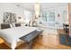 Bright bedroom with hardwood floors, white walls, a white bed, a brick fireplace, a chandelier, and a window at 565 Candler St, Atlanta, GA 30307