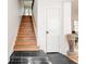 Grand entryway with a wood staircase, black tile flooring, a white door, and a decorative wood sculpture at 565 Candler St, Atlanta, GA 30307