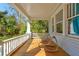 Inviting covered front porch with hardwood floors, rocking chairs, and white railings offering peaceful outdoor space at 565 Candler St, Atlanta, GA 30307