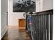 Hallway with hardwood floors, white walls, a black railing with a bike, and natural light streaming through doorway at 565 Candler St, Atlanta, GA 30307