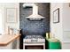 Modern kitchen with stainless steel range hood, green storage and painted brick detail at 565 Candler St, Atlanta, GA 30307