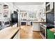 Open-concept kitchen featuring stainless steel appliances, black countertops, and hardwood floors at 565 Candler St, Atlanta, GA 30307