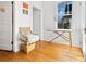 Cozy room with a vintage chair, ironing board, hardwood floors, and natural light from the window at 565 Candler St, Atlanta, GA 30307