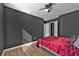 This bedroom features dark walls, light-colored floors, a ceiling fan, and a closet, providing a calming and relaxing atmosphere at 10330 Wisteria Ln, Jonesboro, GA 30238