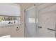 Marble tiled walk-in shower with sliding glass door and safety bars near window at 2007 Manassas Dr, Woodstock, GA 30189