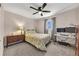 Bedroom with ceiling fan, a bed with floral patterned comforter, and neutral colored walls and gray carpeting at 2007 Manassas Dr, Woodstock, GA 30189