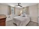 Neutral bedroom with a bed dressed in all white bedding, carpeting, and two windows with natural light at 2007 Manassas Dr, Woodstock, GA 30189