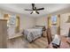 Well-lit bedroom with a ceiling fan, large windows, and a functional desk area for work or study at 2007 Manassas Dr, Woodstock, GA 30189