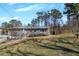 Home's exterior with a pink front door, gray siding, lush greenery, and a spacious yard at 2007 Manassas Dr, Woodstock, GA 30189