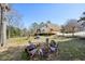 Expansive backyard with mature trees, a deck, and play equipment at 4805 Mystere Sw Ln, Lilburn, GA 30047