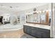 Bathroom featuring a double sink vanity, garden tub, and an expansive mirror over the vanity at 4805 Mystere Sw Ln, Lilburn, GA 30047