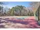 Full tennis court and viewing area surrounded by trees at 4805 Mystere Sw Ln, Lilburn, GA 30047