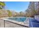 Tennis court with fence and canopy surrounded by mature trees at 4805 Mystere Sw Ln, Lilburn, GA 30047