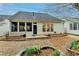 Home's back exterior featuring a landscaped yard and sunroom at 1635 Vinery Ave, Cumming, GA 30041