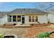 Home's back exterior with patio, mulch, and landscaped flowerbeds at 1635 Vinery Ave, Cumming, GA 30041