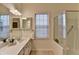 Modern bathroom offers a glass shower, dual sinks, and natural light, creating a serene and functional space at 1635 Vinery Ave, Cumming, GA 30041