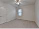 Neutral bedroom with a ceiling fan, carpeted floor, and window offering natural light creates a calm and inviting atmosphere at 1635 Vinery Ave, Cumming, GA 30041