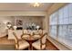 Dining room with hardwood floors, a round wood table and bright natural light from the large window at 1635 Vinery Ave, Cumming, GA 30041