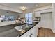 Bright kitchen with stainless steel sink, black countertop, white cabinets and view to dining and living rooms at 1635 Vinery Ave, Cumming, GA 30041