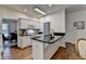 White eat-in kitchen with stainless steel appliances, black countertops and view of dining room at 1635 Vinery Ave, Cumming, GA 30041