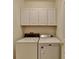 This laundry room provides functionality with a washer, dryer, and cabinets for storage at 1635 Vinery Ave, Cumming, GA 30041