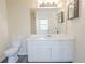 Bathroom vanity featuring a sink, mirror, and storage cabinets at 244 Amelia Garden Way, Lawrenceville, GA 30045