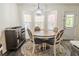 Bright dining area featuring a round table, chairs, and a large window bringing in natural light at 244 Amelia Garden Way, Lawrenceville, GA 30045