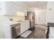 Well-lit kitchen with stainless steel appliances, white cabinets, and dark wood-look flooring at 244 Amelia Garden Way, Lawrenceville, GA 30045