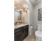 Powder room featuring a modern vanity with granite countertop, decorative mirror and a toilet at 322 Gray Shingle Ln, Woodstock, GA 30189