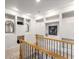 Hallway area with shelves and display nooks along the wall with a light carpet and wood railing at 322 Gray Shingle Ln, Woodstock, GA 30189