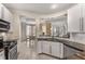 This kitchen features white cabinets, stainless steel appliances, granite counters and a view into the dining room at 322 Gray Shingle Ln, Woodstock, GA 30189