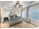 Comfortable main bedroom featuring a ceiling fan, bedside tables, and large windows providing natural light at 322 Gray Shingle Ln, Woodstock, GA 30189