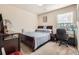 Cozy bedroom with carpet flooring, a comfortable bed, a window providing natural light, and functional desk space at 3362 Brockenhurst Dr, Buford, GA 30519