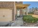 Inviting home entrance adorned with a wreath, features a well-maintained lawn, landscaping, and a cozy front porch at 3362 Brockenhurst Dr, Buford, GA 30519