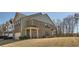 Exterior view of the townhome featuring a brick facade, covered entryway, and well-maintained lawn at 3362 Brockenhurst Dr, Buford, GA 30519